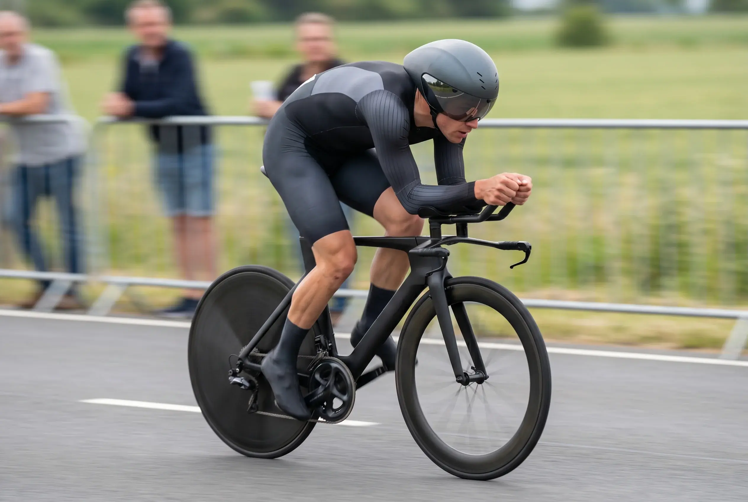 Ciclista professionista in cronometro individuale su bici da crono, casco aerodinamico e posizione raccolta sul manubrio